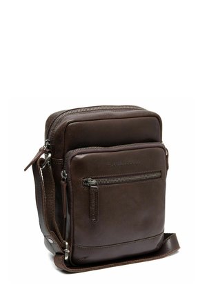 Sac bandoulière en cuir marron avec un compartiment principal zippé, une poche avant, une sangle ajustable et une finition texturée. Forme rectangulaire compacte.