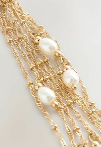 Gold-tone multi-chain necklace featuring lustrous white pearls and small gold beads, with a textured, twisted design throughout.