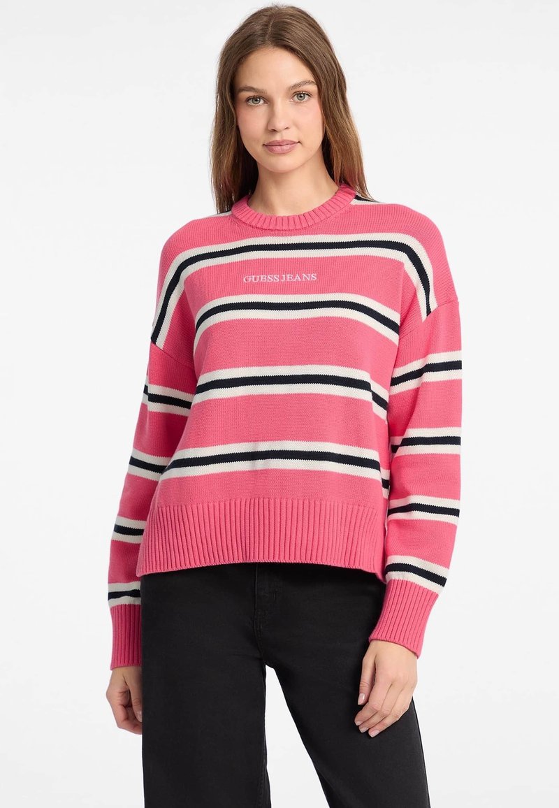 Pinstripiger Pullover mit geripptem Halsausschnitt und Saum, versehen mit schwarz-weißen Streifen. Auf der Vorderseite steht der Text "GUESS JEANS".