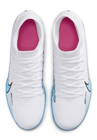 Valkoiset urheilukengät, joissa on teksturoitu päällinen, siniset yksityiskohdat sivuilla, musta logo ja vaaleanpunainen pohja. Varustettu perinteisellä nauhakiinnitysjärjestelmällä.