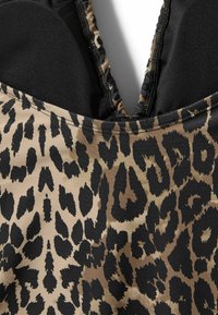 Plavky s leopardím vzorom, čiernym lemovaním, hladkou látkou a hlbokým výstrihom do V so zberanými okrajmi.