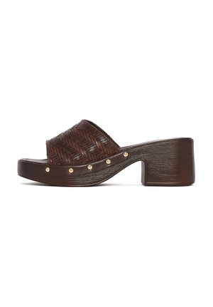 Bruine hakken clog-sandaal met gevlochten bovenriem en kleine gouden studs langs de zijkant van de houten plateauzool.