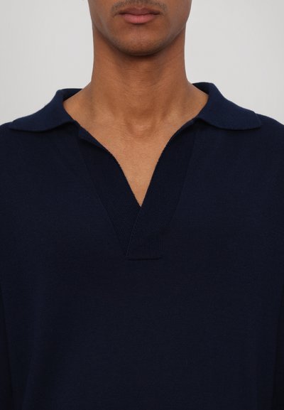 Maglione blu navy con un tessuto testurizzato, caratterizzato da un ampio scollo a V e colletto corto e piatto. Design semplice e minimalista senza motivi.