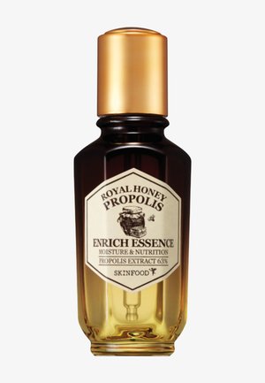 Flacon en ambre foncé avec bouchon doré étiqueté "Royal Honey Propolis Enrich Essence" pour l'hydratation et la nutrition avec 63 % d'extrait de propolis.