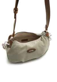 Bolso de hombro beige claro con exterior de tela suave, detalles de cuero, cierre con cremallera y una correa de cuerda estampada.