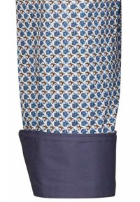 Manica di camicia a motivo con un design ripetuto di cerchi blu e elementi marroni su uno sfondo bianco, con un polsino blu navy uniforme.