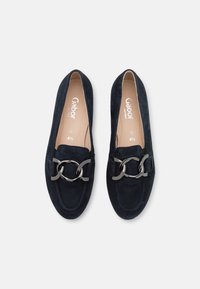 Námornické semišové mokasíny s kulatou špičkou, zdobené stříbrným řetízkem přes přední část a pohodlnou stélkou.