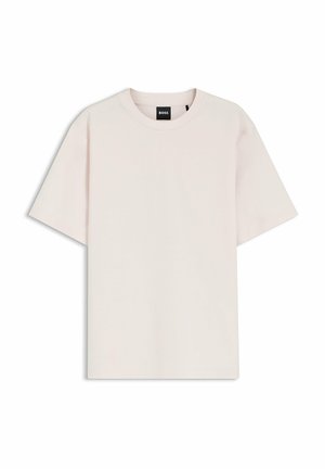Kremowy bawełniany T-shirt z krótkim rękawem, okrągłym dekoltem i czarną metką marki BOSS wewnątrz kołnierzyka.