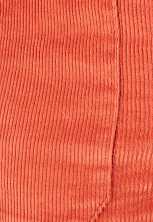 Gestructureerde oranje corduroy stof met verticale ribbels, gekenmerkt door een zachte, fluweelachtige oppervlakte en een schone verticale naad aan één zijde.