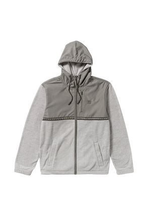 Giacca grigia con cappuccio e chiusura con zip; presenta una parte inferiore in fleece grigio chiaro e una parte superiore in nylon più scura; include corde di regolazione e tasche laterali.
