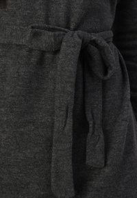 Grau, weiche textilartige Bekleidung mit einem gebundenen Gürtel an der Taille. Die Textur ist glatt mit einem leichten Stretch und eignet sich für Freizeitkleidung.