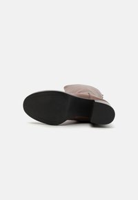 Botte de cheville en cuir marron avec un design décontracté, semelle plate en caoutchouc noir et texture lisse. Présente des détails de couture subtils.