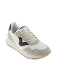 White sneaker featuring gray suede accents, black logo, and textured sole. Lace-up design with a padded collar for comfort.