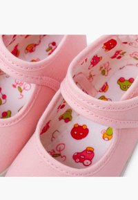 Rosa Canvas-Kinderschuhe mit runder Zehenpartie und Klettverschlussriemen. Das Innenfutter zeigt ein buntes Muster mit Cartoon-Fahrzeugen und Charakteren.