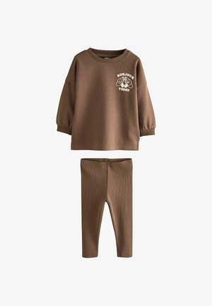 Smeđa majica dugih rukava s natpisom "Bonjour Today" i crtanom grafikom, uparena s odgovarajućim smeškim rebrastim tajicama za decu.