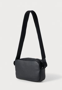 Juoda odinė per petį nešiojama rankinė su tekstūruotu paviršiumi, stačiakampio formos, su užtrauktuku ir nuimamu audiniu dirželiu.