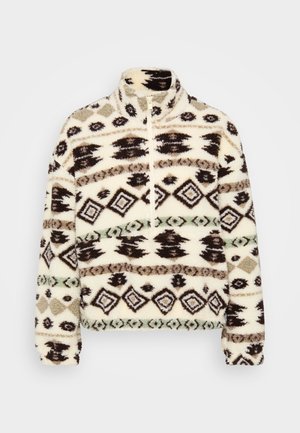 Fleece-halpzip-pullover vaaleassa värissä, jossa on geometrisia mustia, ruskeita ja mintunvihreitä kuvioita, korkea kaulus ja ribbidut hihansuut.