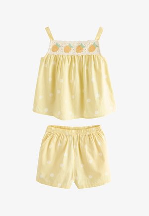 Haut sans manches jaune avec détail brodé de fruits et short jaune assorti à pois blancs, taille élastique sur le short.