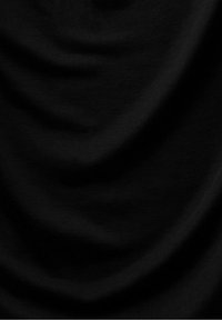 Tissu noir avec une texture douce et lisse et des plis délicats, montrant des réflexions subtiles de lumière et des variations d'ombre.