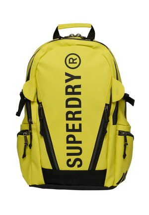Sac à dos jaune vif avec des détails de fermeture éclair noirs verticaux et un grand logo noir "SUPERDRY" à l'avant, plusieurs poches latérales zippées et une poignée supérieure.
