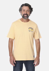 Camiseta de algodón amarilla clara con cuello redondo, mangas cortas y un diseño impreso de Vespa en el lado izquierdo del pecho. Ajuste casual y textura suave.