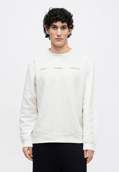 Biela mikina s okrúhlym výstrihom a dlhými rukávmi. Na prednej strane je potlačený čierny text. Mäkká textúra a voľný strih.