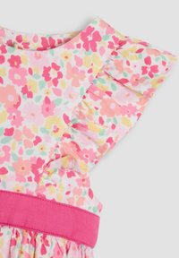 Vestido floral con un estampado en rosa y amarillo, hombros con volante y una cinturilla rosa sólida. Confeccionado con una tela ligera de textura suave.