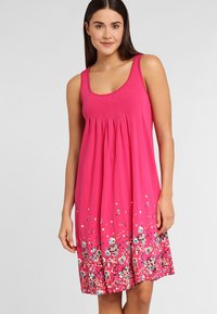 Pink sleeveless dress with a pleated bodice and floral print at the hem, featuring blue and white flowers against a vibrant background.