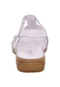 White leather sandal with multiple straps, featuring a padded insole and a textured tan sole. Rear view highlights the open design.