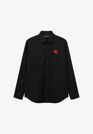 Černá košile s dlouhým rukávem na knoflíky s špičatým límcem a malým červeným motivem hlavy s brýlemi na levé straně hrudi.