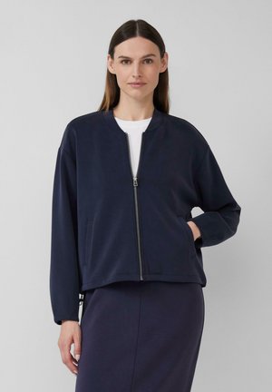Veste bomber bleu marine en matériau doux avec fermeture éclair à l'avant, poches latérales et poignets côtelés. Présente une coupe décontractée et un col rond.
