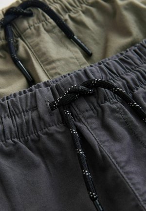 Dwie pary elastycznych szortów: jedna w kolorze oliwkowej zieleni, a druga w ciemnoszarym. Obie wykonane są z teksturowanej tkaniny i mają czarne sznurki ze srebrnymi akcentami.