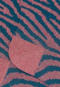 Maglione lavorato a maglia con un motivo a strisce zebrato blu e rosa, con una finitura testurizzata e dettagli di polsino rosa uniforme.