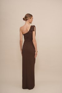 Braunes einseitiges Kleid mit einer Schleifendetails, figurbetonte Silhouette, bodenlanges Design, aus glattem Stoff und mit einem verdeckten Reißverschluss auf der Rückseite.