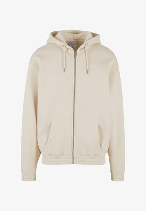 Gaisbekas krāsas kapuciņa ar rāvējslēdzēju. Iekļauj trīsstūri ar auklām, elastīgu jostasvietu un divām priekšējām kabatām. Mīksts audums un smalks logo elements.