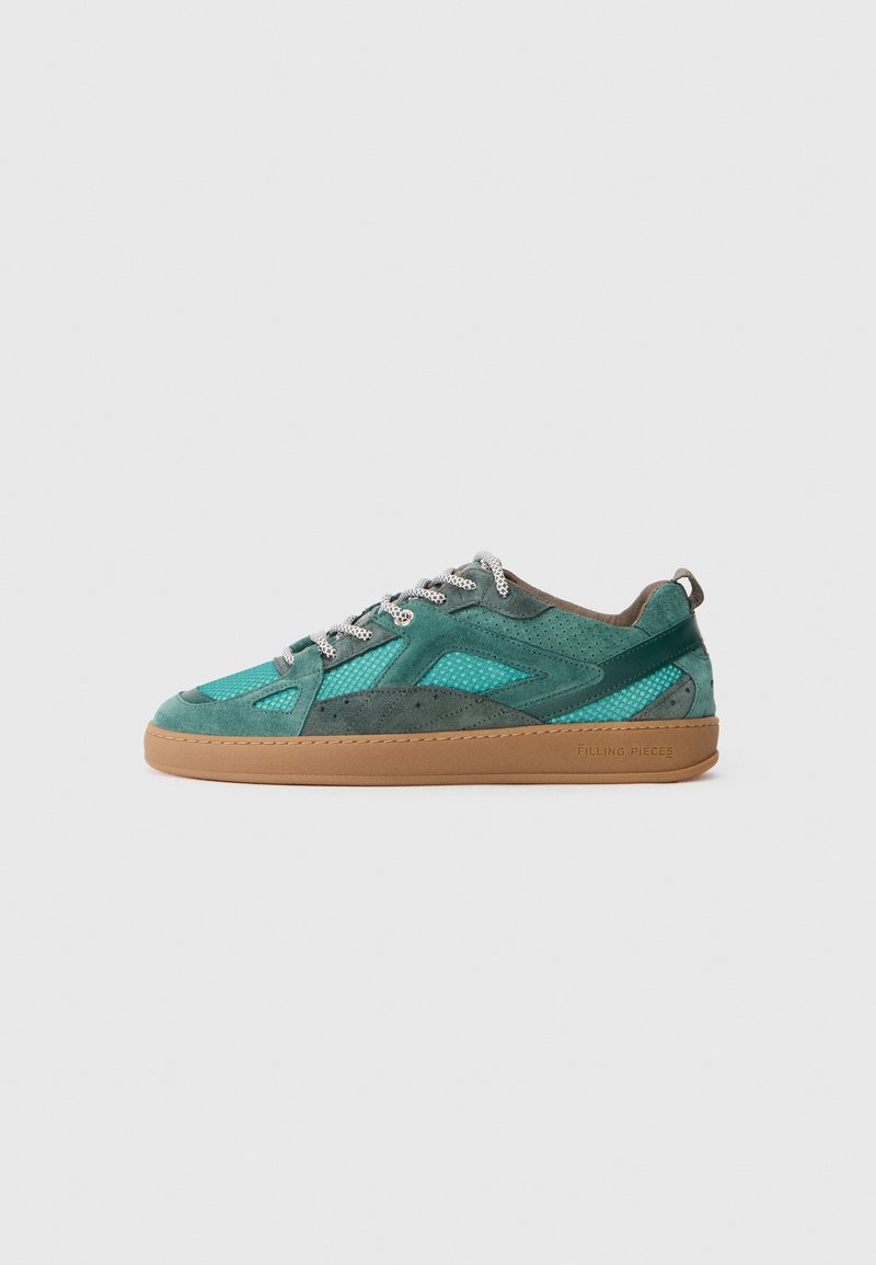 Grønne og turkise sued sneakers med en mesh-overlay, med sølvsnørebånd og en brun gummisåle. Sidebranding og teksturerte detaljer er synlige.