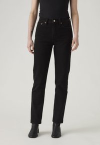Black denim jeans with a high waist, fitted through the hips, straight leg, featuring copper hardware and classic five-pocket design.