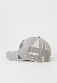 Casquette de baseball grise avec un devant structuré, un dos en mesh, un logo brodé et une sangle réglable. Équipée d'une visière incurvée et d'étiquettes de marque.
