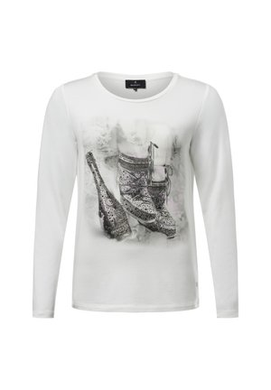 White long-sleeve shirt featuring a printed design of sparkling shoes and a champagne bottle, with a soft texture and crew neckline.