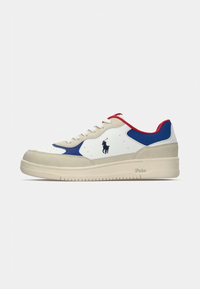 Vit sneaker med blå och röda accenter, läder- och mockamaterial, rund tå, platt sula och logotypdetalj på sidan.