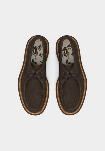 Καφέ καθημερινά δερμάτινα παπούτσια με κορδόνια, ραμμένες σόλες και σχέδιο στα πέλματα, εμφανιζόμενα από πάνω σε απλό λευκό φόντο.