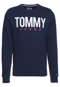 Námořnická modrá mikina z bavlněné směsi s dlouhými rukávy, kulatým výstřihem a odvážným bílým a červeným textem "TOMMY JEANS" přes přední část.