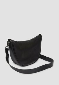 Schwarze Leder-Crossbody-Tasche mit runder Form, strukturiertem Oberflächenmaterial, Reißverschluss und verstellbarem Tragegurt. Minimalistisches Design, keine sichtbaren Beschläge.