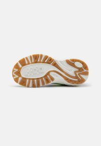 Sola de sapato com uma base branca e secções de borracha laranja e bege, padrões texturizados para aderência e realces elevados para estabilidade.