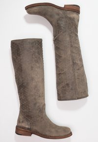 Paio di stivali alti in pelle marrone consumata, con tacco in legno basso e impilato e una sottile texture a motivo a diamante sui foderi.