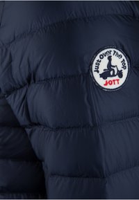 Giacca puffer blu marina in tessuto con texture trapuntata e toppa rotonda con la frase "Just Over The Top" e "JOTT."