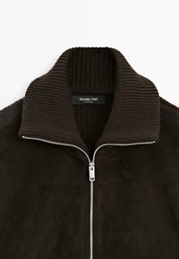 Giacca in suede marrone con colletto a costine, zip argentata e design elegante. Etichetta con la scritta "Massimo Dutti."
