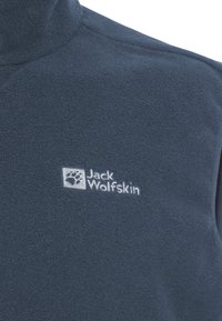 Navy-Fleece-Weste mit hohem Kragen und gesticktem Jack Wolfskin-Logo. Weiche Textur mit glatter Oberfläche und ohne sichtbare Beschläge.