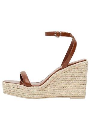 Sandalias de cuña de cuero marrón con una base de rafia trenzada, que cuentan con una delgada correa alrededor del tobillo y una plantilla suave.