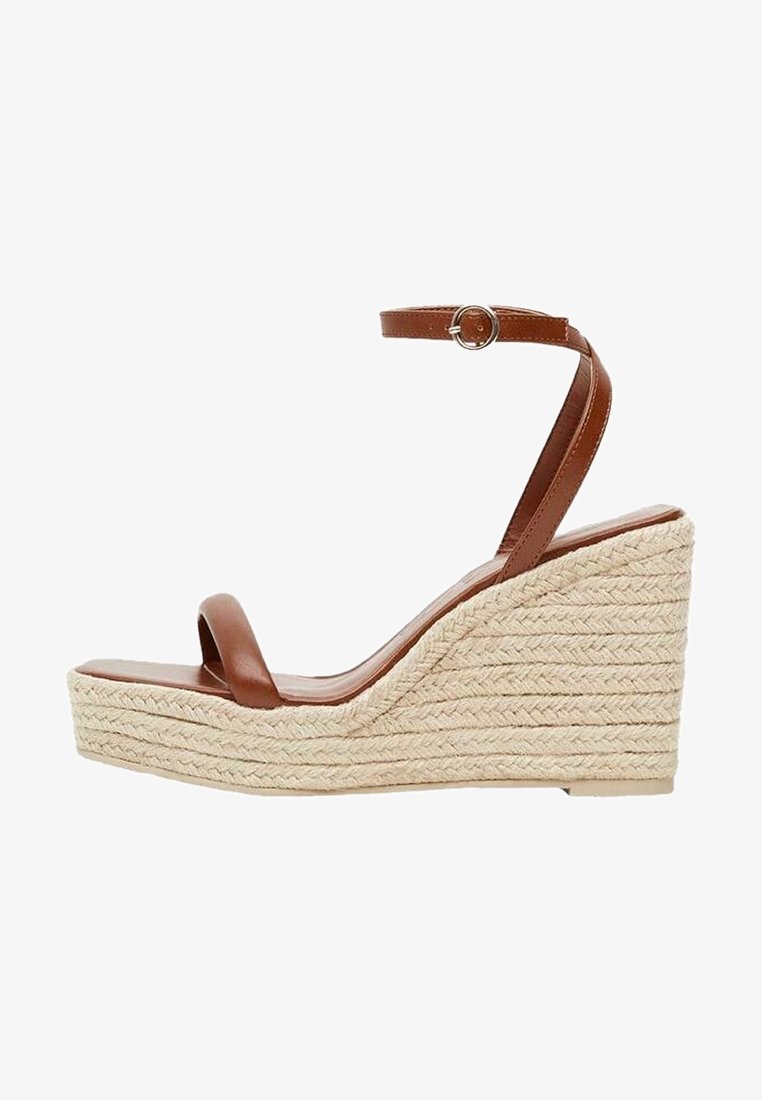 Sandales à talons compensés en cuir marron avec une base en raffia tissée, dotées d'une fine sangle autour de la cheville et d'une semelle intérieure lisse.